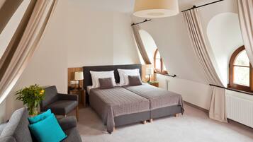 A bedroom with a bed, two nightstands, a chair, and a window with curtains.