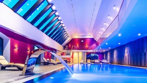 An indoor swimming pool with a modern design, featuring a blue pool, sun loungers, and a glass ceiling. - Uroczysko Siedmiu Stawów & Spa by L'Occitane (Niemcza)