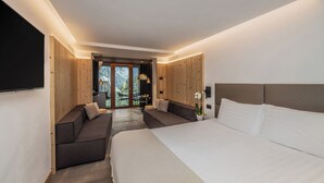 A modern bedroom with a large bed, a sofa, and a dining area with a view.