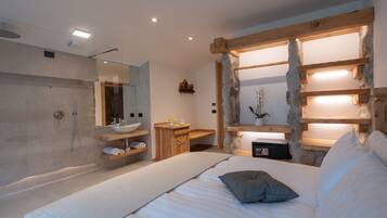 Una camera da letto moderna con un letto grande, una testiera in legno, una mensola a muro, un comodino e uno specchio di grandi dimensioni.