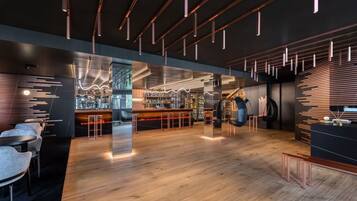 Eine moderne Bar mit Holzboden, Barhocker und Pendelleuchten.