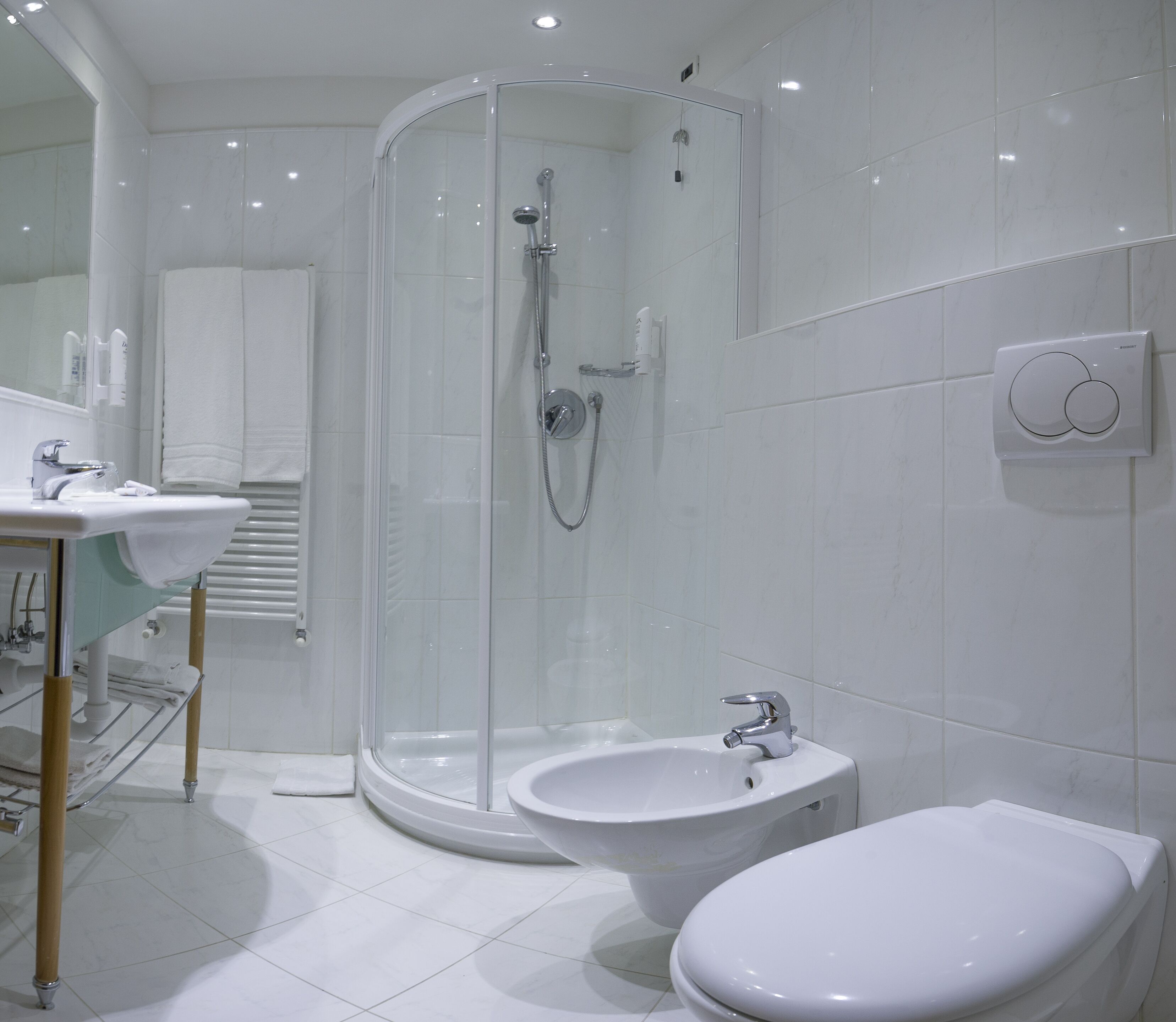 Un bagno moderno con doccia vetrata, lavandino e bidet.