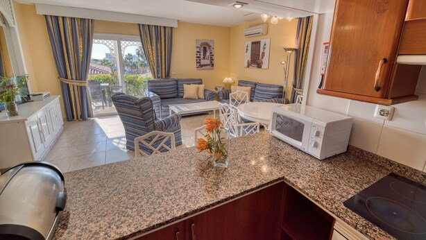 A modern kitchen with granite countertops, a microwave, and a built-in stove. - Ona Sueño Azul (Adeje)