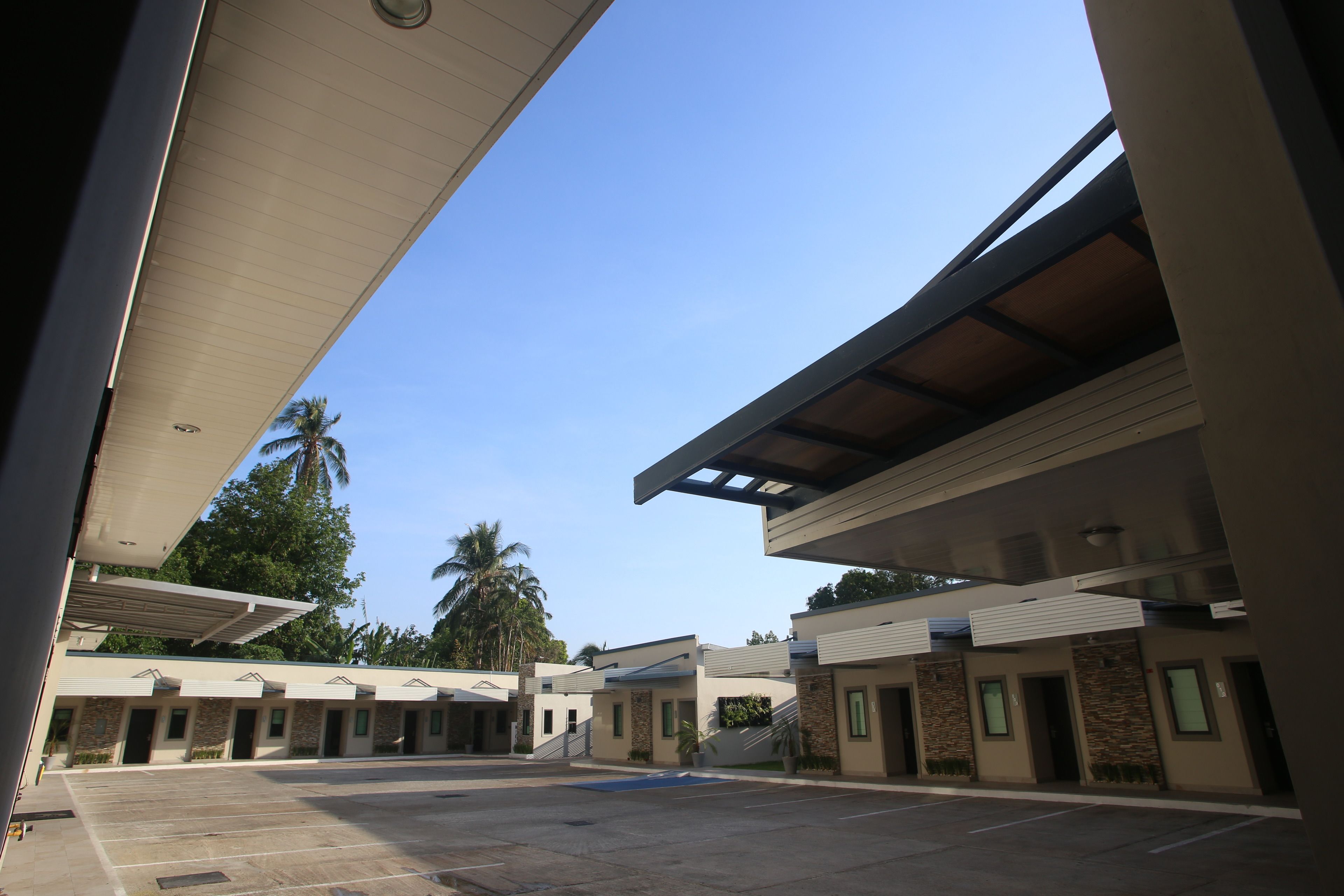 Um edifício moderno com área de estacionamento coberta e vários quartos com fachada de pedra.