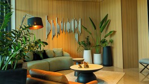 Una sala de estar moderna con un sofá, una mesa de centro y detalles decorativos en la pared.