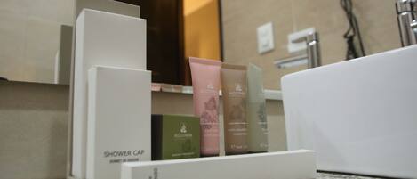 A shower area with a soap dispenser and a bottle of shower gel.