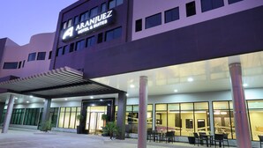 Un hotel moderno con un letrero llamativo que dice "ARANJUEZ HOTEL & SUITES".