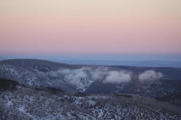 A mountainous landscape with snow-covered terrain and a clear sky.