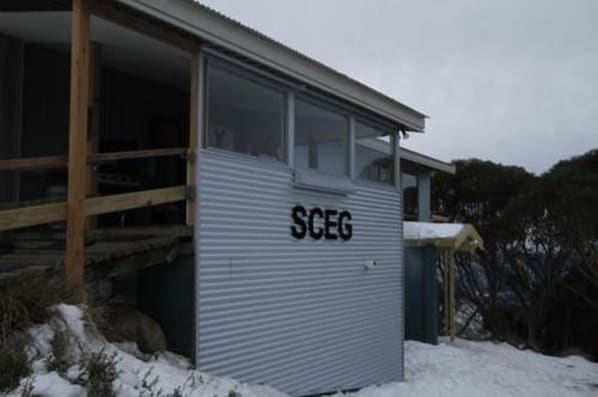 A metal building with the label "SCEG" on its side, surrounded by snow.