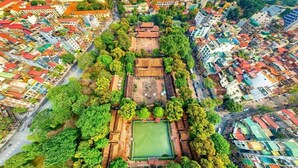 Vista aérea de un patio tradicional con una plaza central, rodeado de edificios con techos de tejas rojas.