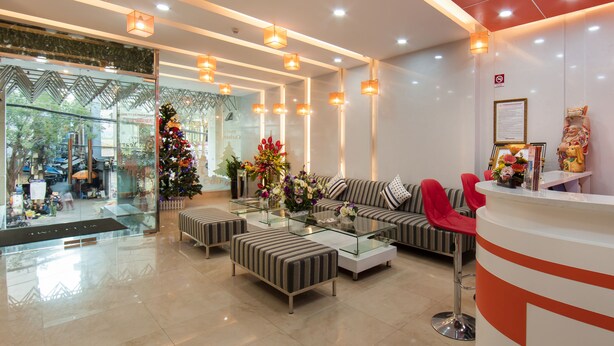 Un vestíbulo moderno con un muro de cristal, un árbol de Navidad y una recepción.