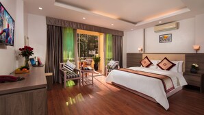 Una habitación de hotel moderna con una cama grande, un escritorio y vistas al exterior.