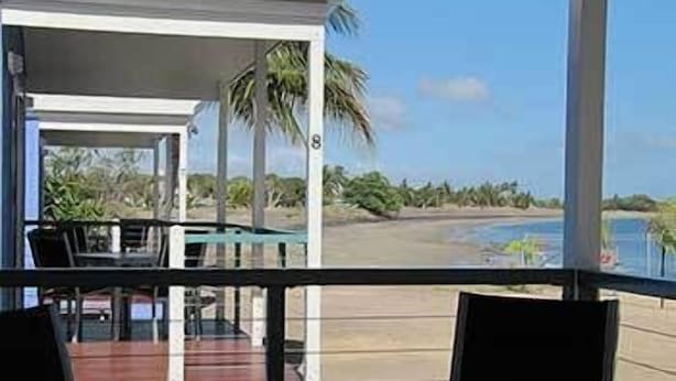 A room with a view of a beach and palm trees. - Tropical Beach Caravan Park (Bowen)