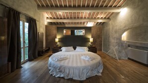Un dormitorio con una cama grande, suelo de madera y techo inclinado con vigas a la vista.