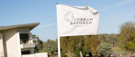 Una bandera con el texto "Cobra Barooga Golf Club" en un asta.