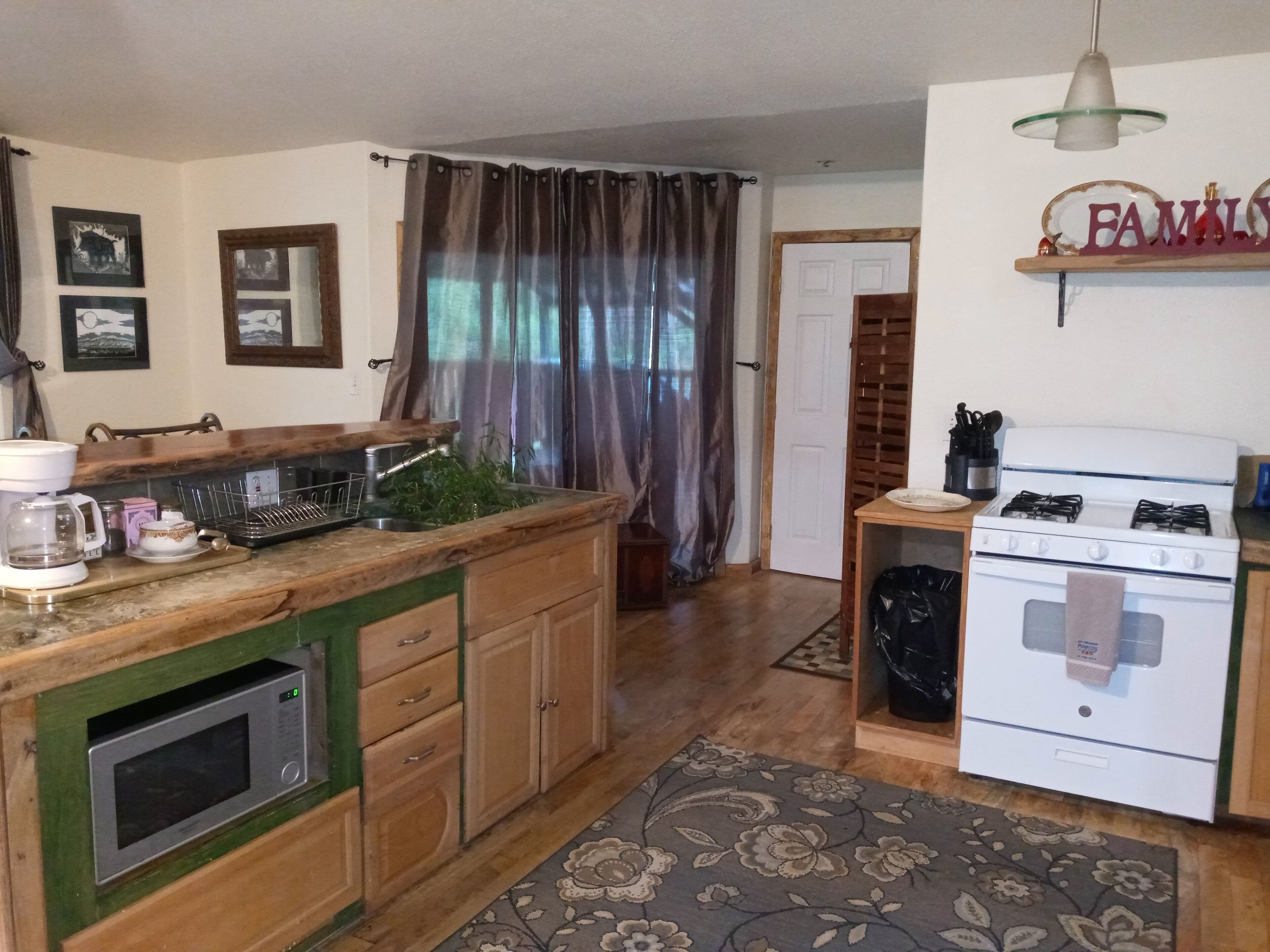 A kitchen with a microwave, stove, and coffee maker.