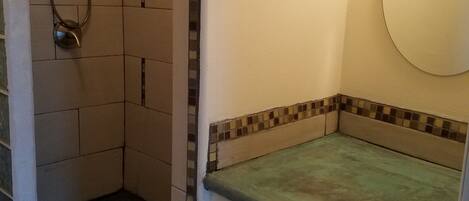 A small bathroom with a shower, a toilet, and a mirror.