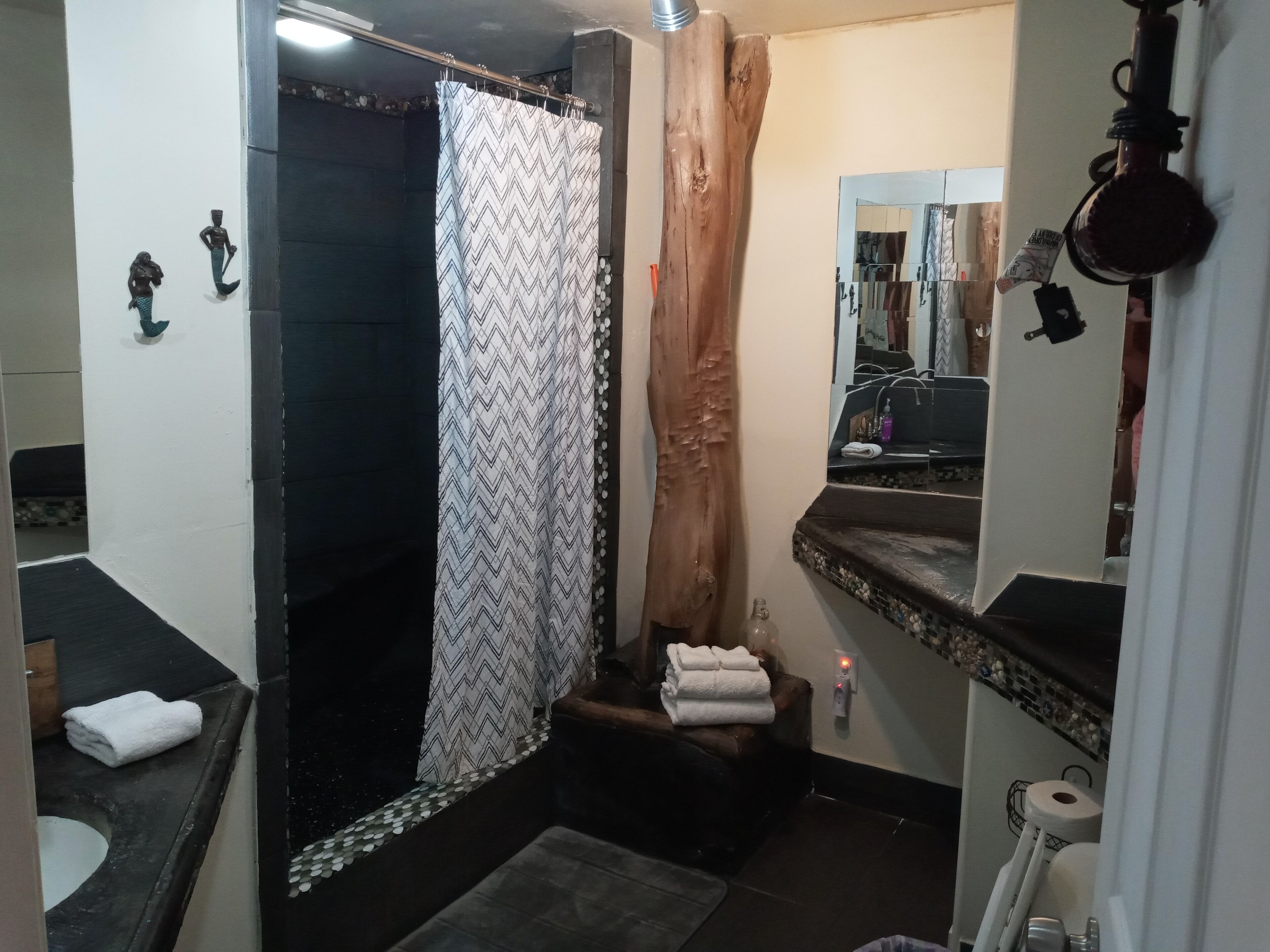 A bathroom with a shower, a sink, and a toilet.
