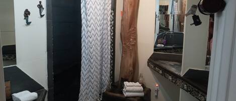A bathroom with a shower, a sink, and a toilet.