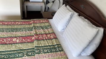 Een hotelkamer met een bed, een bureau met een magnetron en een stoel.