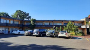 A multi-story motel with several parked cars in front. - Longview Inn (Longview)