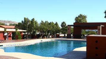 Una piscina con zona techada y patio.