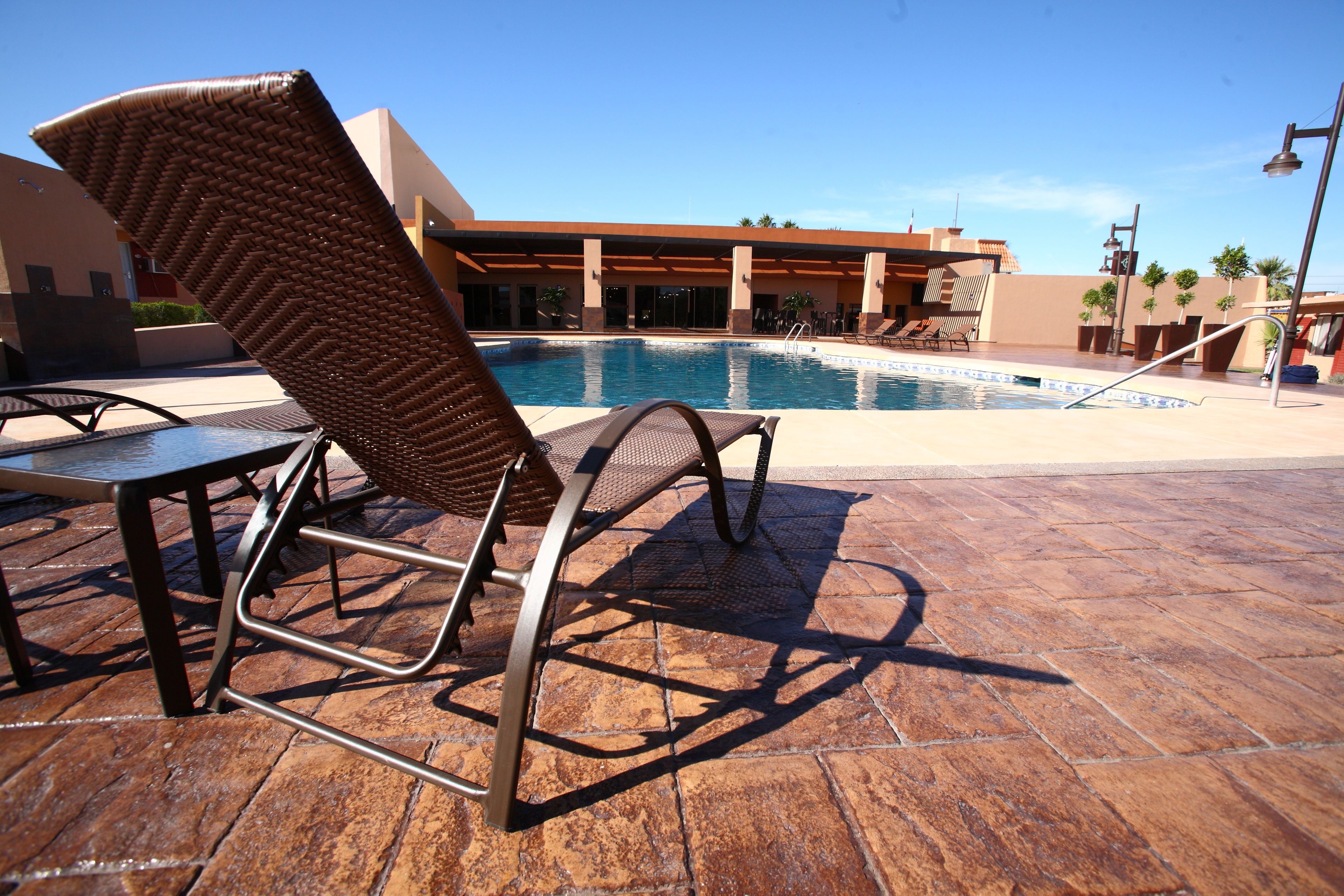 A poolside area with lounge chairs and a pool.