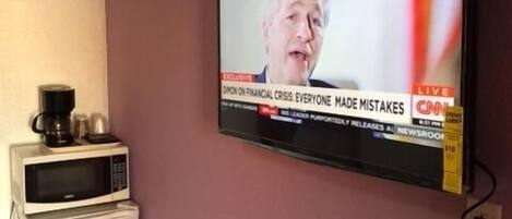 Un téléviseur fixé au mur diffusant un journal télévisé.