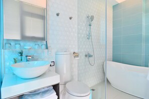 A modern bathroom with a large white sink, toilet, and bathtub.