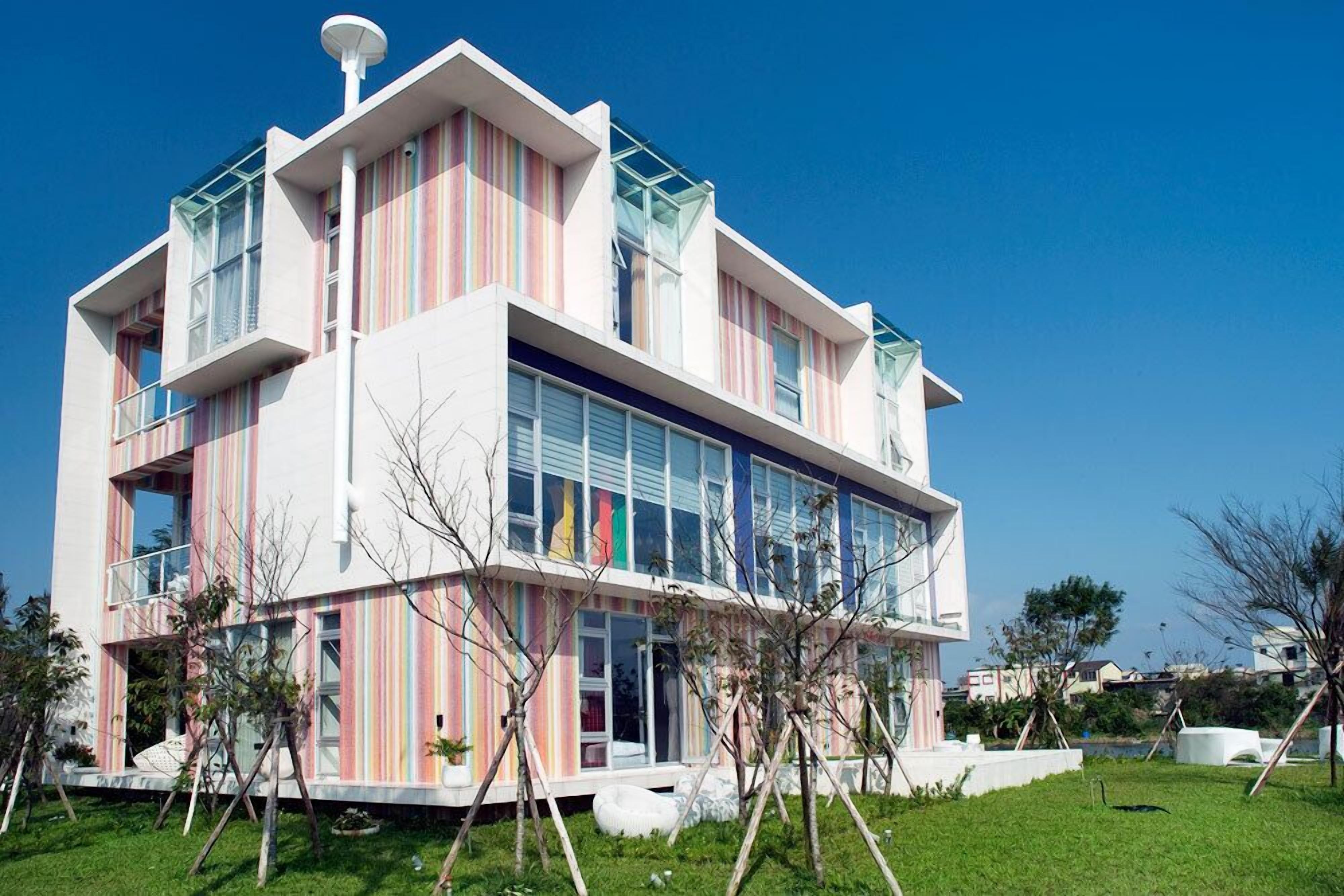 A modern two-story building with large windows and a flat roof.