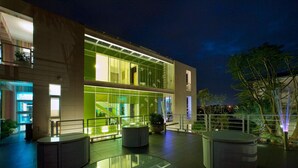A modern building with a glass facade, outdoor seating area, and a staircase leading to an upper level. - La Palette (Luodong)