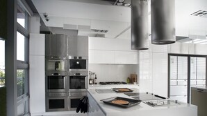 A modern kitchen with stainless steel appliances, a large island, and ample natural light. - La Palette (Luodong)