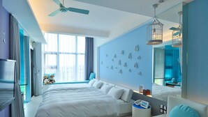 A modern hotel room with a large bed, a ceiling fan, a large window with curtains, a wall-mounted light fixture, and a mirror reflecting the room. - La Palette (Luodong)