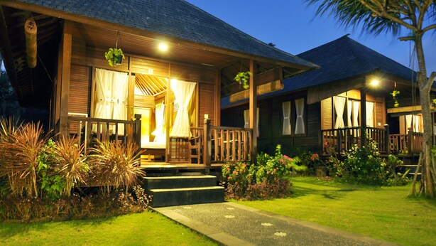 A wooden house with a porch, steps, and a garden. - Aman Gati Hotel Balangan (Jimbaran)