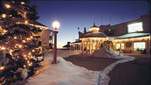 A snow-covered street with a building featuring a dome and a sign that reads "The Main Inn." - Fern Resort (Ramara)