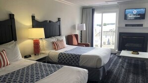 A hotel room with two beds, a TV, a fireplace, and a view of the outside. - Fern Resort (Ramara)