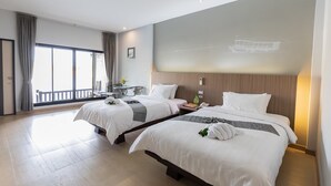 A hotel room with two beds, a balcony, and a large window. - Banpu Resort Trat (Trat)