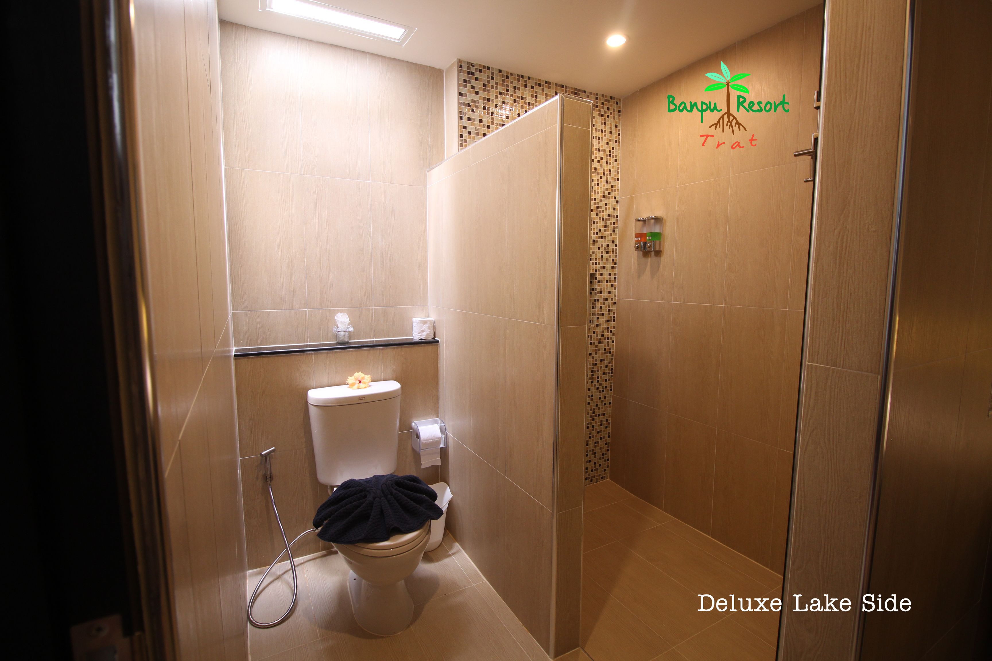 Un baño con inodoro, ducha y un cartel de Banpu Resort Trat.