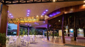 An indoor dining area with tables and chairs, a ceiling with lights, and a view of the outside. - Banpu Resort Trat (Trat)