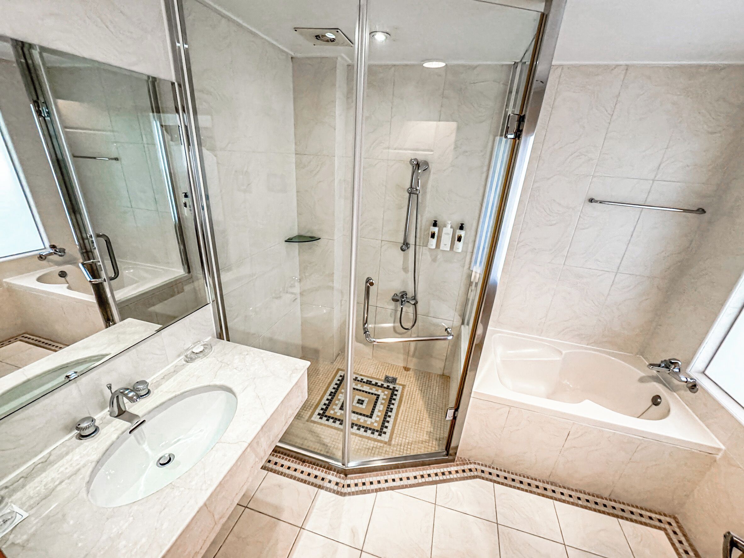 A modern bathroom with a glass-enclosed shower, a separate bathtub, and a vanity with a sink.