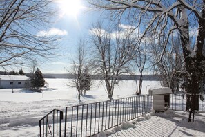 A snow-covered landscape with a metal fence and a snow-covered structure.