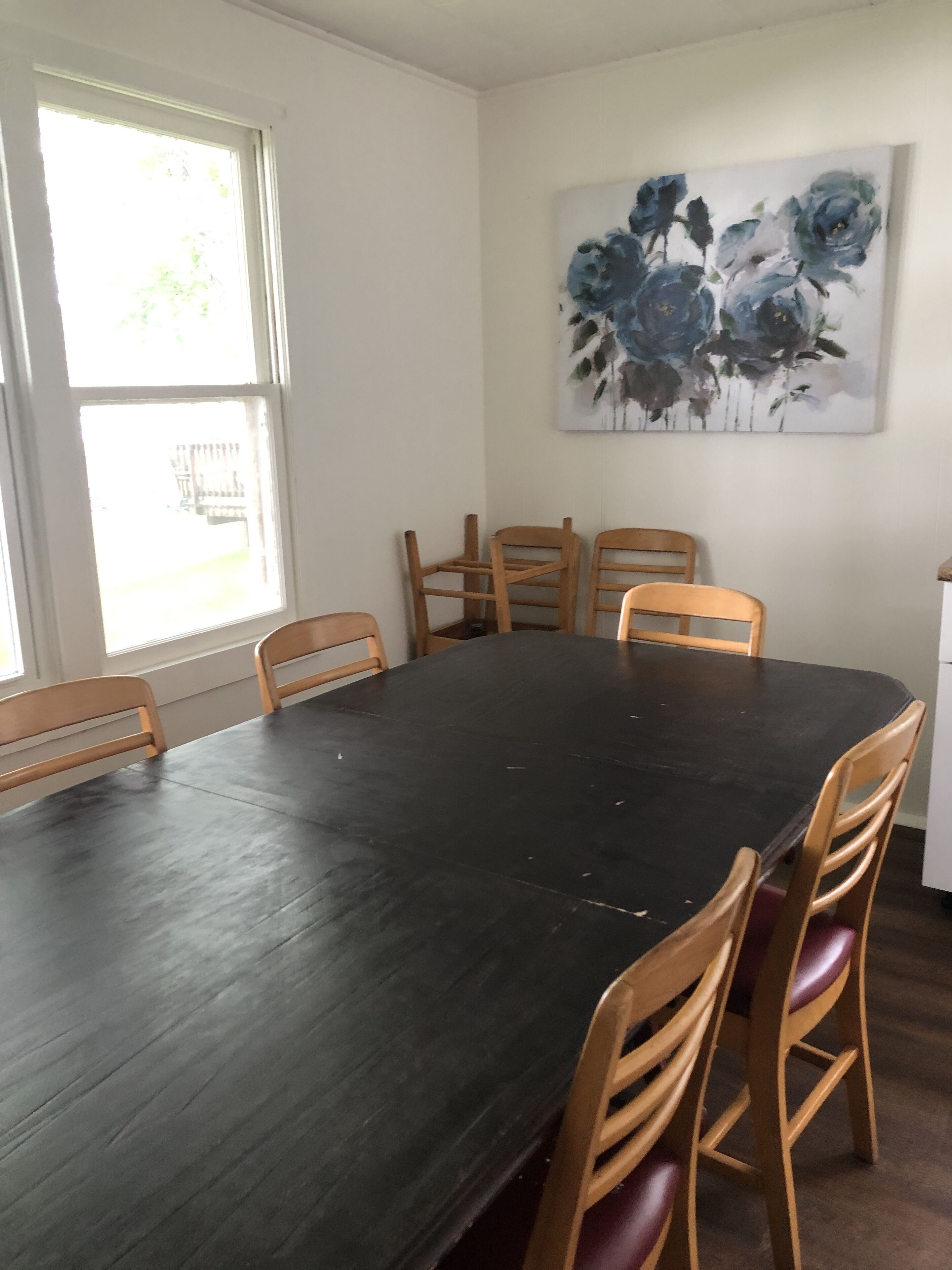 A dining area with a dark wooden table and six wooden chairs.