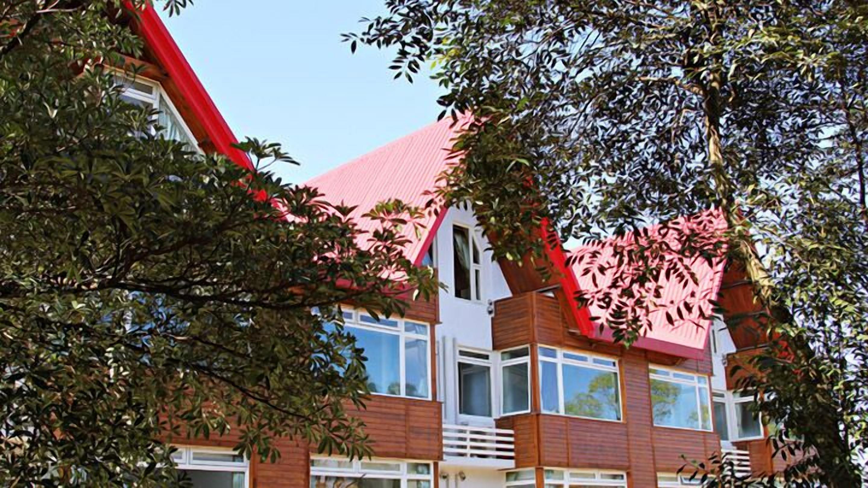 Un immeuble à plusieurs étages, doté d’un toit rouge et d’une façade en bois.
