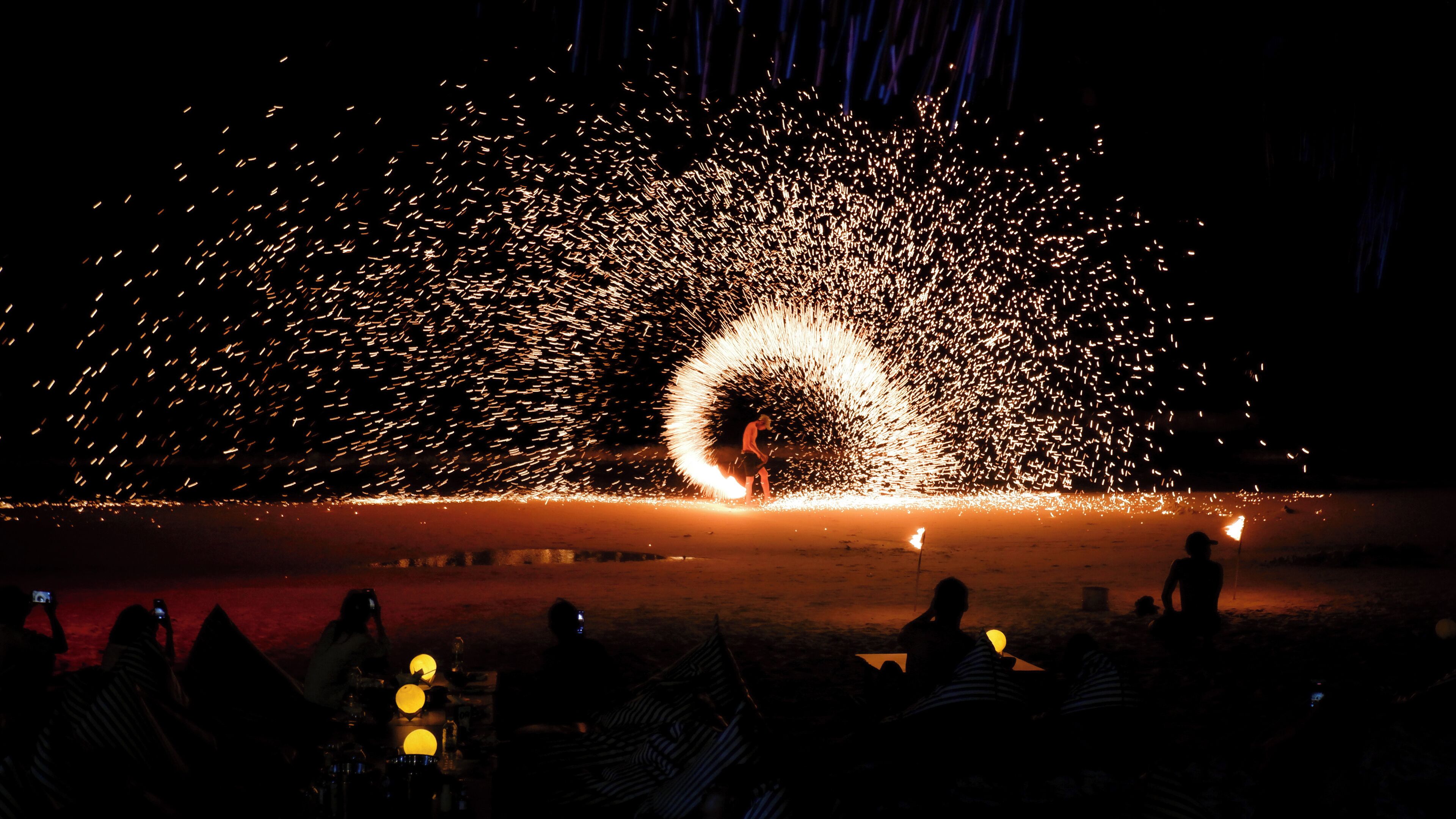 A nighttime outdoor event with a large, circular fire display.