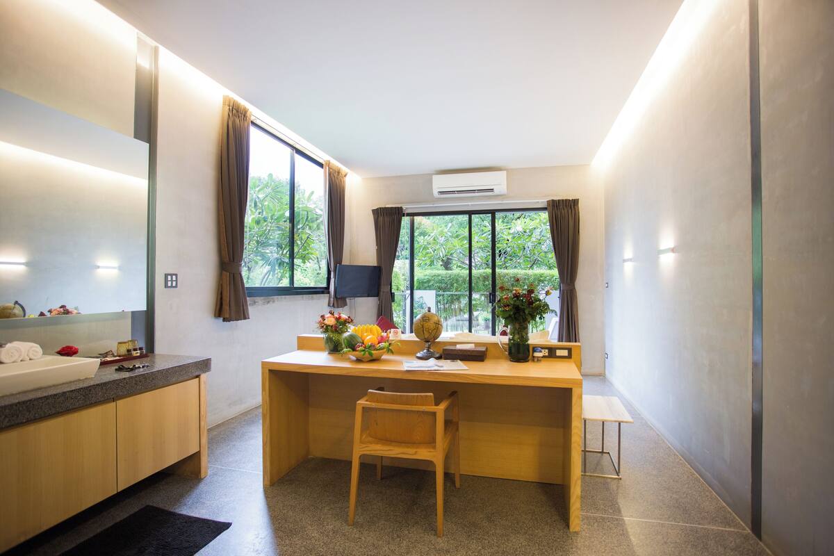 A modern kitchen with a wooden countertop, a sink, and a window with curtains.