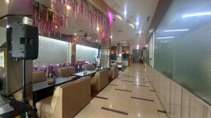 A restaurant with booths and tables, a patterned wall, and hanging decorations. - Clubhouse World Hotel Jakarta Bandengan (Jakarta)