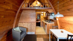 Een gezellig chalet met een slaapkamer op de verdieping, een eethoek en een keuken.