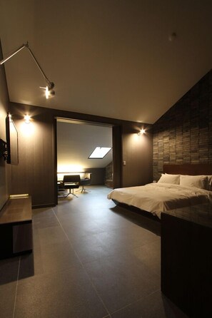 A modern bedroom with a large bed, a desk, and a skylight. - Valentine Hotel (Goyang)