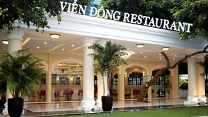 Het uiterlijk van VIEN DONG RESTAURANT met een overdekte ingang, grote kolommen en potplanten.