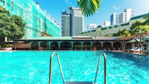 Une piscine avec des échelles en métal, entourée d’immeubles et d’arbres.